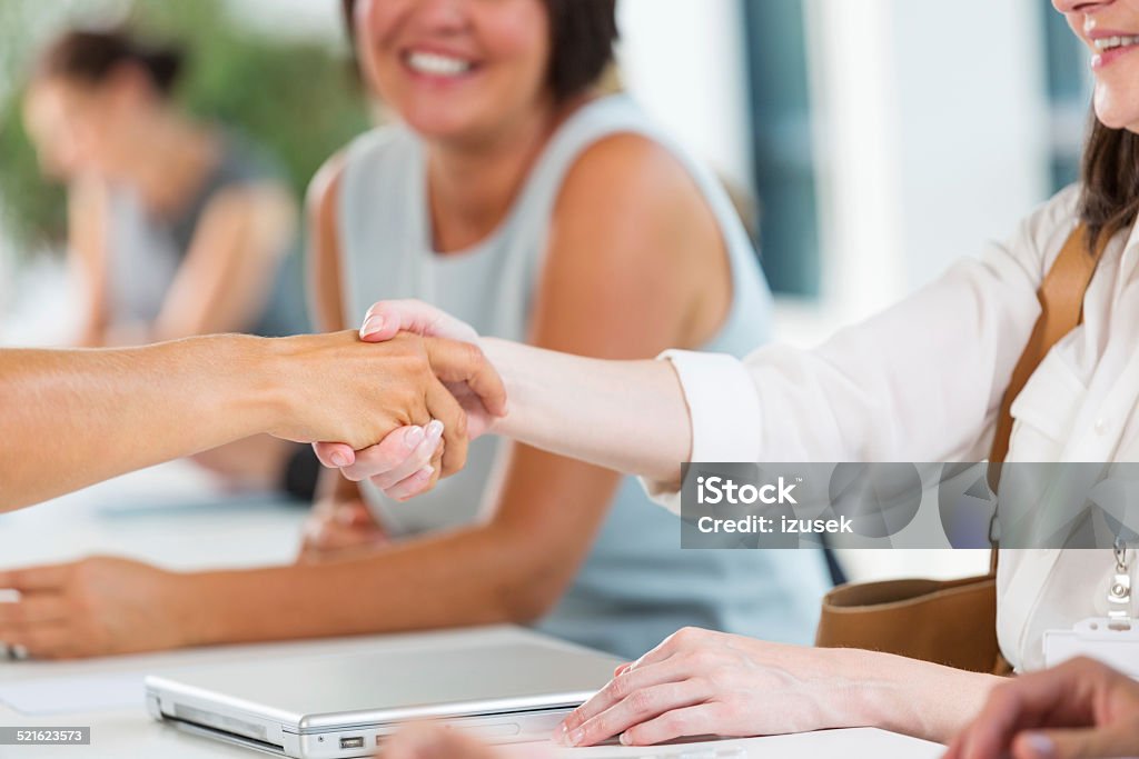 Businesswomen shaking hands Group of businesswomen having meeting in an office. Close up of handshake.  Job Fair Stock Photo