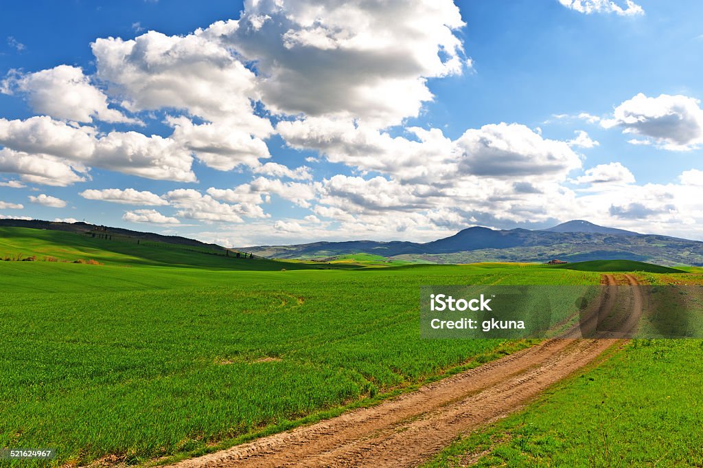 Tuscany Clouds Farmhouse and Green Sloping Meadows of Tuscany Agricultural Field Stock Photo