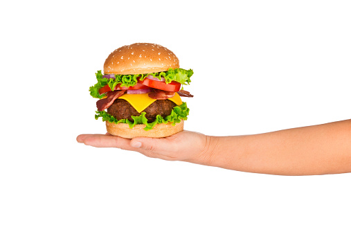 Clean Shot of Hand Holding Big and Tasty Cheeseburger Against White Background. Shot on Canon EOS 5D Mark II