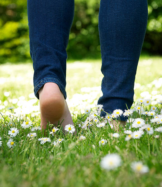 istock Woman walking barefoot in the park 521652133