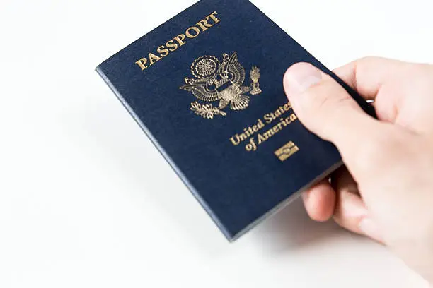 new U.S. passport with microchip holder by a person on a white background with free space for typing.
