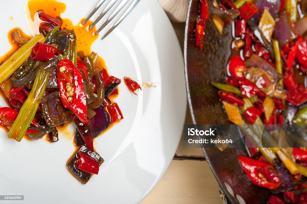 fried chili pepper and vegetable on a wok pan fried chili pepper and vegetable on a iron wok pan Bok Choy Stock Photo