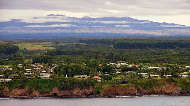 The Big Island of Hawaii just east of Hilo with Mauna Loa volcano in the background.  The top of the volcano is visible in the clouds which is unusual as the volcano top is usually obscured in clouds.