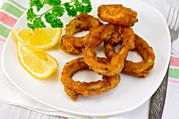 istock Calamari fried with lemon and fork on plate 521664239
