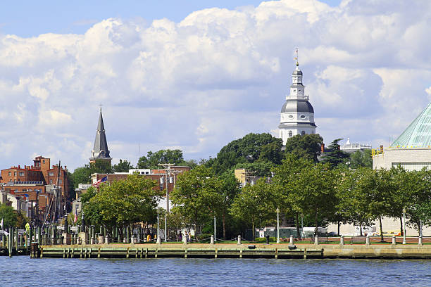 State House in Colonial Annapolis, Maryland, USA Annapolis, Maryland, USA - August 18, 2012:  View from a boat in Annapolis Harbor showing the Maryland Statehouse and the Annapolis waterfront.  Nearby is the United States Naval Academy. View of the State House dome in historic Annapolis, Maryland, USA. skipjack stock pictures, royalty-free photos & images