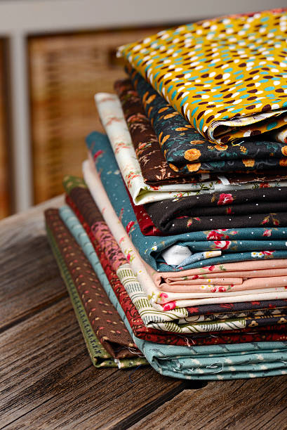 istock heap of cloth fabrics on wooden table 521666113