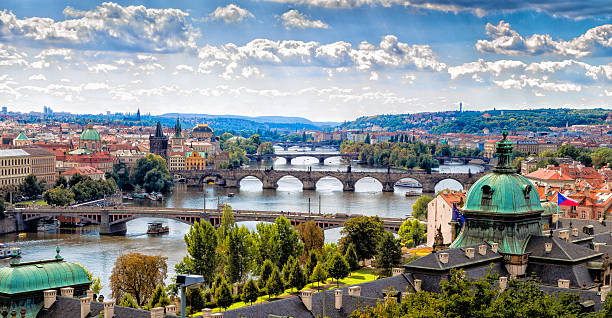 Bridge and rooftops of Prague Scenic view of bridges on the Vltava river and of the historical center of Prague: buildings and landmarks of old town with red rooftops and multi-coloured walls. prague stock pictures, royalty-free photos & images