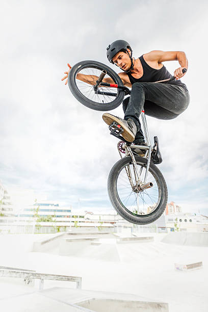 BMX biker BMX biker performing a stunt in ramp park. bicycle stunts stock pictures, royalty-free photos & images