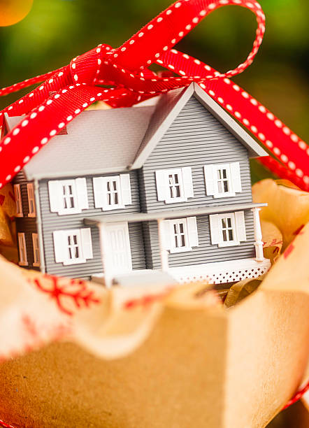 istock New home in gift box in front of Christmas tree 521683333