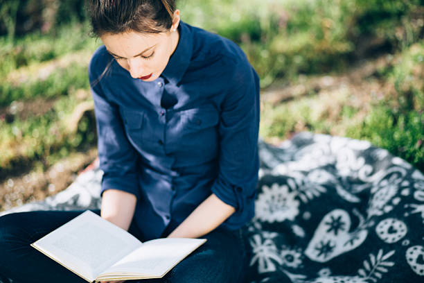 istock Girl reading a book in nature 521684794