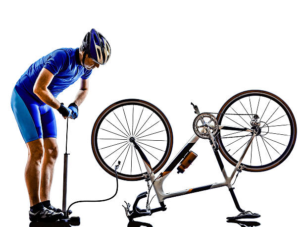 istock cyclist repairing bicycle silhouette 521685489
