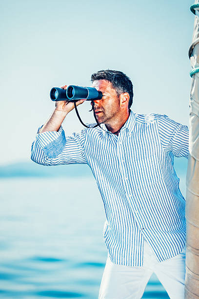 istock Sailor with binoculars on sailboat 521685552