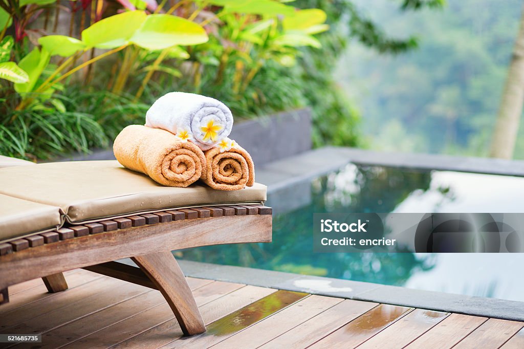 Towels with white frangipani flowers in spa Towels with white frangipani flowers in a Balinese spa Hotel Stock Photo