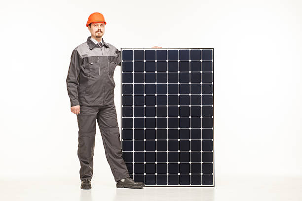 worker in uniform with solar panels stock photo