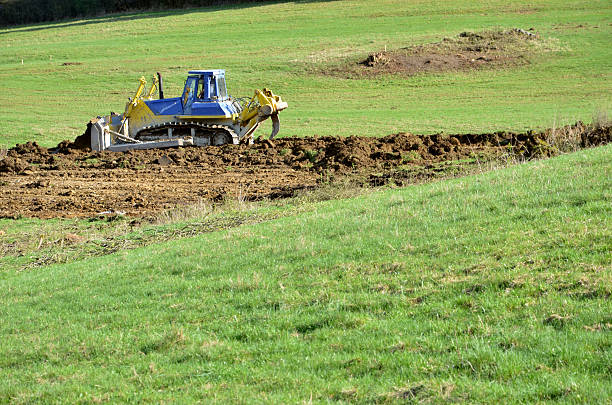 istock Yellow blue bulldozer working on field 521687938