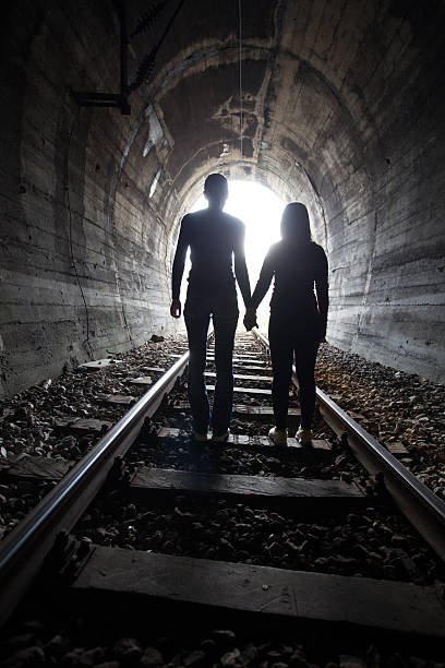 istock Couple walking together through a railway tunnel 521693362