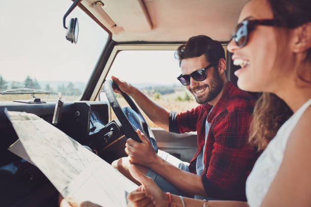 istock Happy young couple with a map in the car 521694074