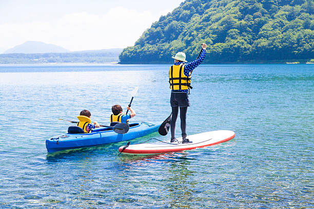 canoa e paddle carta d'imbarco in famiglia - paddleboard oar women lake foto e immagini stock