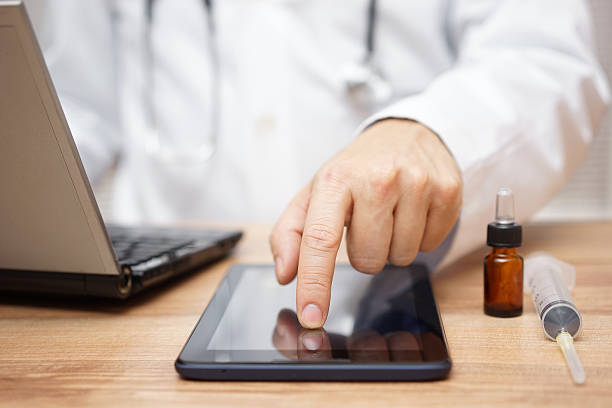 istock Doctor in clinic at work using tablet and laptop computer 521696738