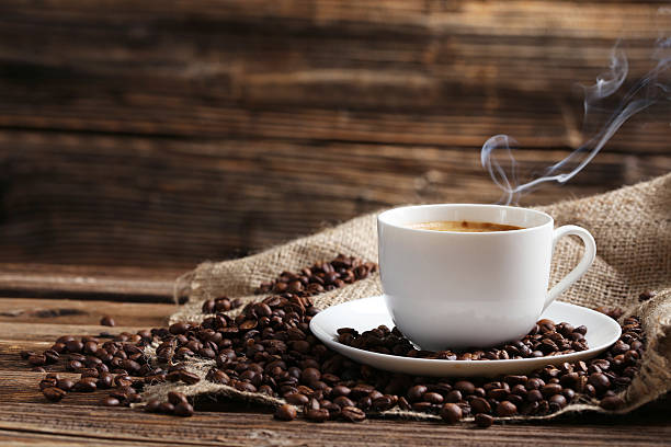 Cup of coffee with coffee beans Cup of coffee with coffee beans on a brown wooden background espresso photos stock pictures, royalty-free photos & images