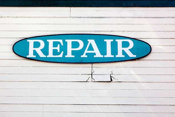 istock Blue Oval Repair Sign on Clap Board Building Wall 521698507