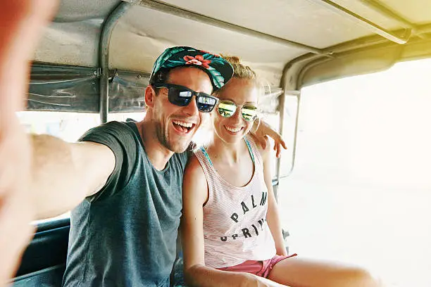 Shot of a young couple taking a selfie in a rickshaw