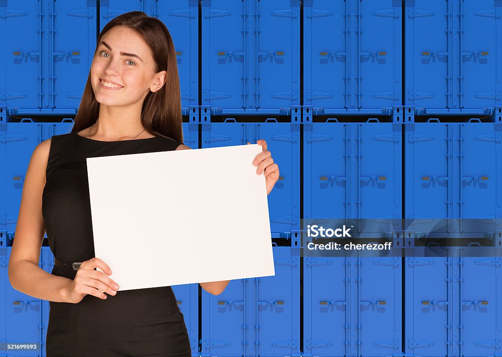 Businesswoman hold paper sheet. Wall of blue containers Businesswoman hold paper sheet. Wall of blue containers as backdrop Businesswoman Stock Photo