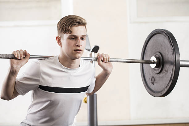 youth engaged in sports exercises with a barbell. stock photo