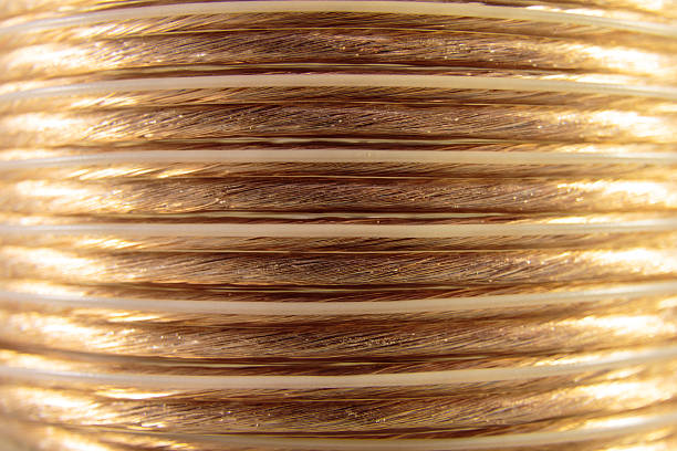 Coiled Speaker Wire Closeup of golden coiled speaker wire - abstract concept home cinema system stock pictures, royalty-free photos & images
