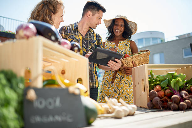 istock Friendly woman tending an organic vegetable stall at a farmer 521702592