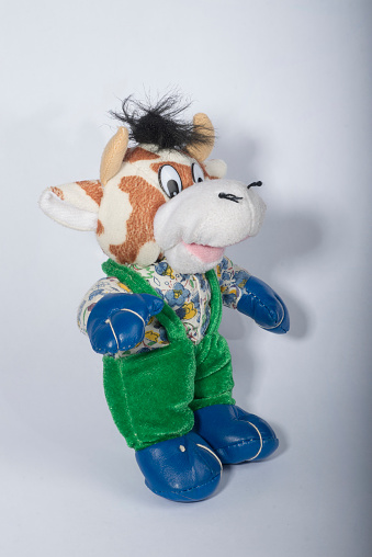 Toy bull athlete in green trousers and blue boxing gloves