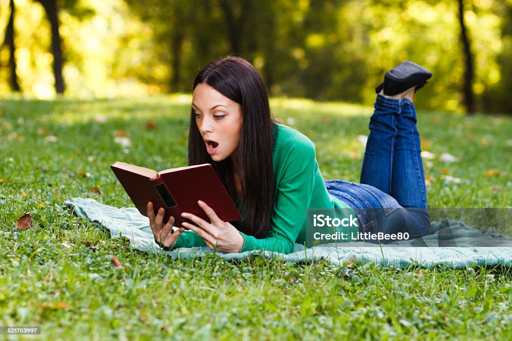 Surprised woman Young woman is surprised about something she had read in a book. 20-24 Years Stock Photo