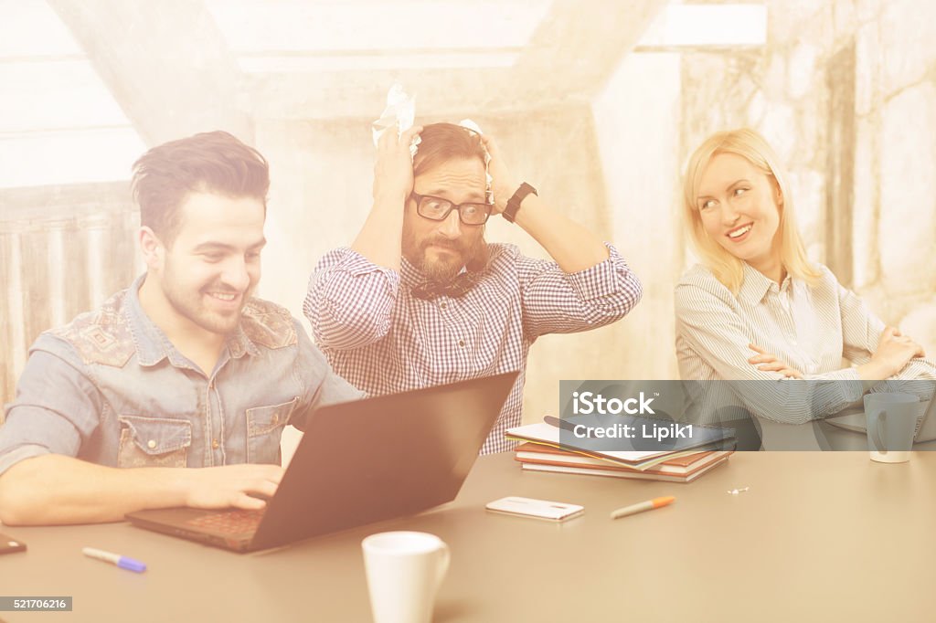 Coworking of businessteam Coworking of businessteam in office upon business projects of their company. Happy people smiling while one of colleague looking stressed and frightened. Adult Stock Photo