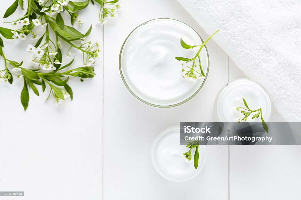 Hierbas cuidado del cuerpo crema cosmética higiénico con flores - Foto de stock de Crema hidratante libre de derechos