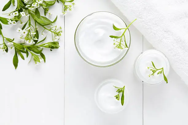 Herbal bodycare cosmetic hygienic cream with flowers skincare product wellness and relaxation medical mask in glass jar on white background