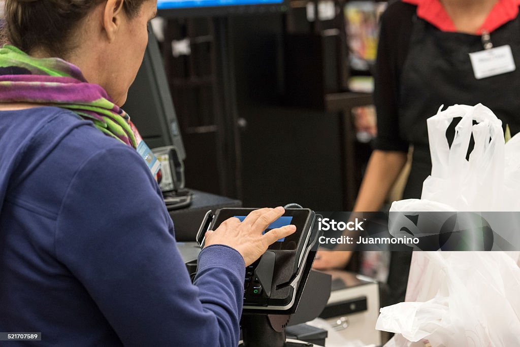 Caucasian woman electronic signing her bill Caucasian woman electronic signing her bill at the supermarket ATM Stock Photo