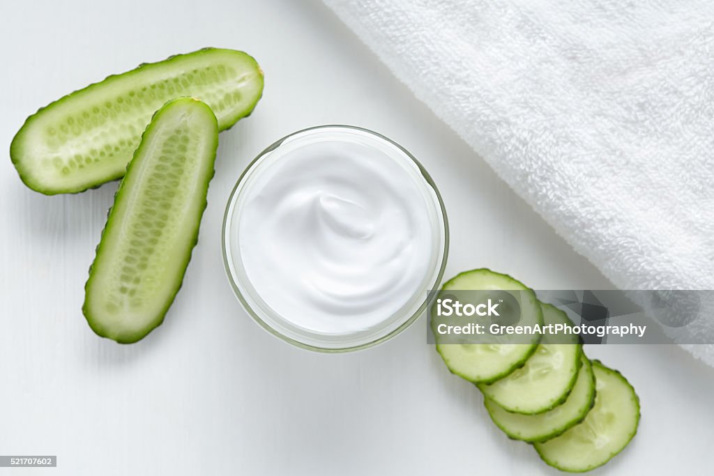 Natural facial cream with cucumber face, skin and body care Natural facial cream with cucumber face, skin and body care hygiene moisture lotion wellness therapy mask in glass jar with towel on white background Cucumber Stock Photo