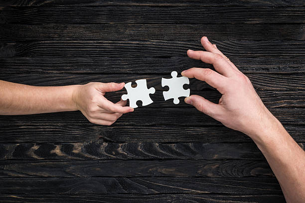 istock hands holding pieces of white puzzle 521707780