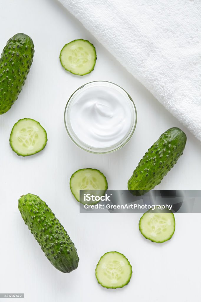Cucumber cosmetic hygiene cream beauty skin, face and body care Cucumber cosmetic hygiene cream beauty skin, face and body care hygiene moisture lotion wellness therapy mask in glass jar with towel on white background. Top view. Alternative Therapy Stock Photo