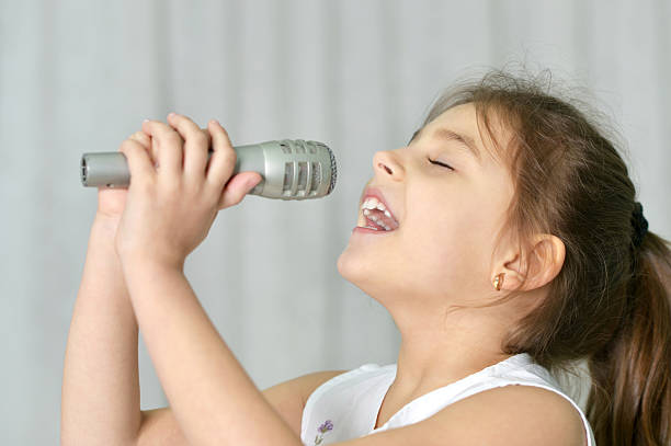 istock Beautiful little girl with microphone 521708422