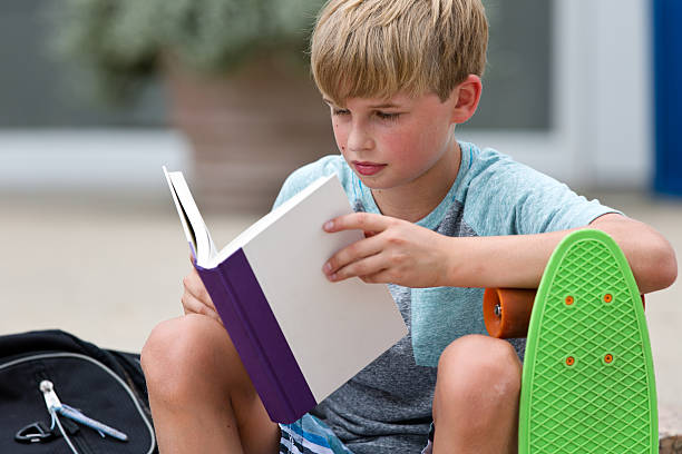 schulkind-nur jungen lesen ein buch - mittelschule bücher stock-fotos und bilder