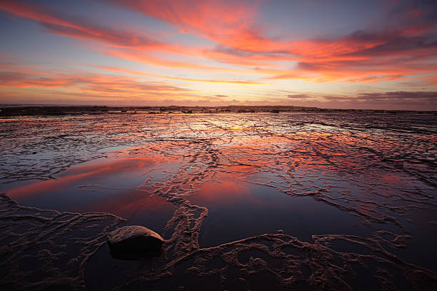 istock Sunrise over Long Reef at low tide with reflectins 521709652