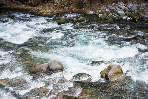istock water of stream flows through between the stones 521710150