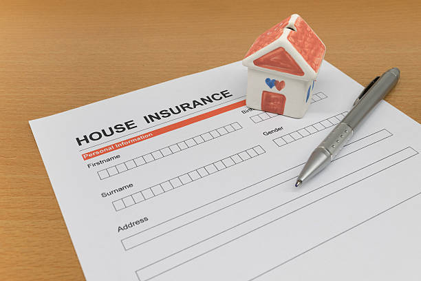 istock House Insurance application form with model house and pen 521710356