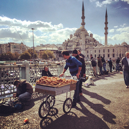 Istanbul, Turkey - October 19, 2014: Man selling pretzels to fishermen on Galata Bridge, Istanbul