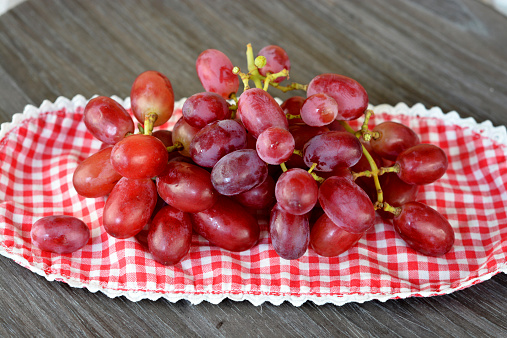 natural red grapes on a wooden background in country style