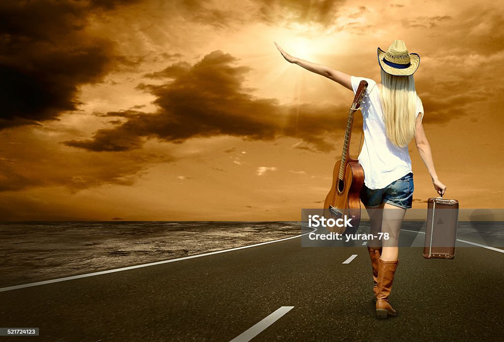 Woman with guitar on the road and her vintage baggage Young woman with guitar on the road and her vintage baggage Adult Stock Photo