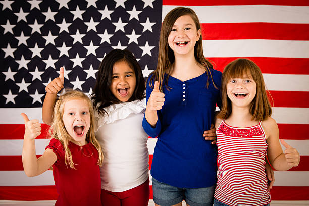 quatro garotas jovem feliz dando polegares para cima da bandeira norte-americana - child flag patriotism thumbs up - fotografias e filmes do acervo