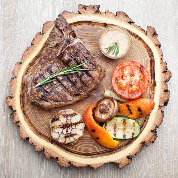 istock Portion of BBQ t-bone steak with  sauce  and grilled vegetables 521727801