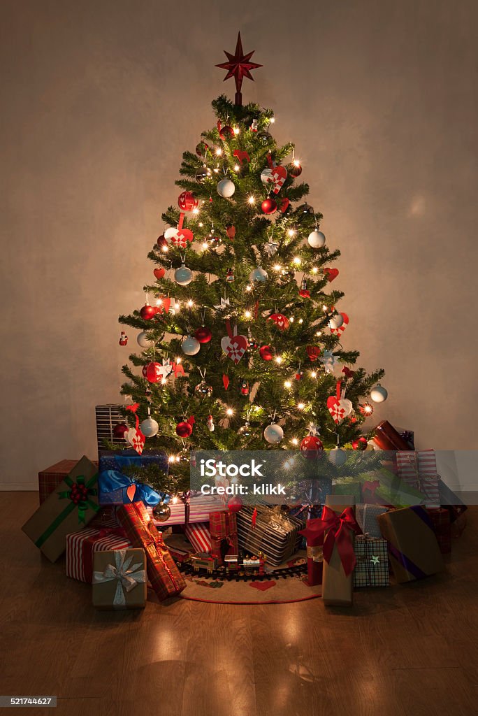 illuminated christmas tree with presents Beautiful christmas tree with lights and presents Christmas Tree Stock Photo